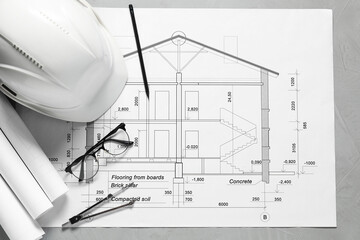 Different architectural drawings, hard hat, pencil, divider and glasses on grey table, flat lay