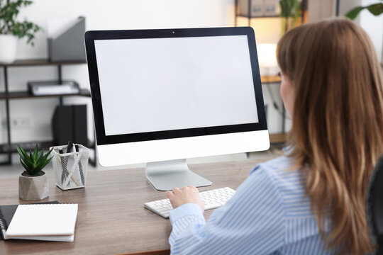 Woman working on computer at wooden desk in office. Mockup for design
