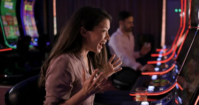 Woman Wins Jackpot on Slot Machine: Excited Female Gambler Celebrates Big Win in Casino