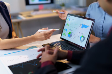 Business colleagues reviewing marketing data on a digital tablet, working together to improve...