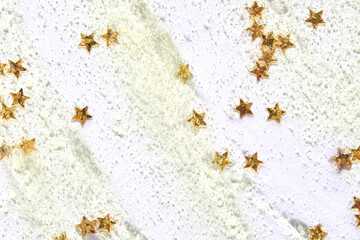 Gold star confetti scattered on white glitter background sparkle celebration.