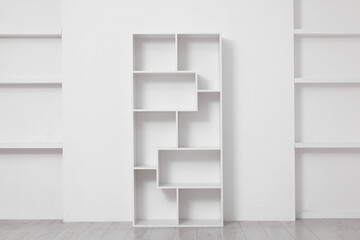 Fototapeta premium Empty shelving unit near light wall indoors