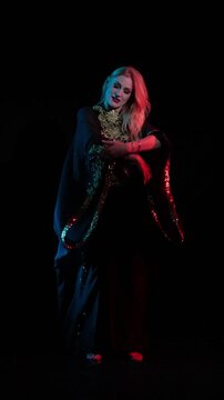 Dancer in black and gold oriental costumes, belly dance on the black background