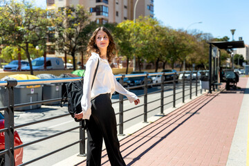 Young businesswoman walking to bus stop in the city