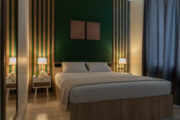 interior of modern and stylish bedroom with double bed and white linens. bedside lamps with soft...