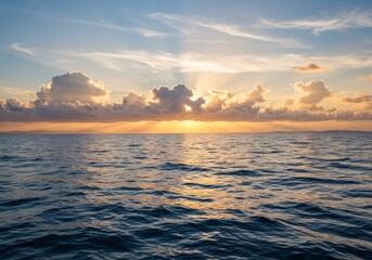Naklejka premium Ocean at sunset with golden rays and clouds over distant mountains.