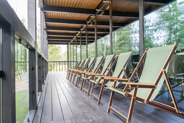 large wooden country house, luxury villa on a green lawn. wooden terrace with sun loungers. view of the green lawn