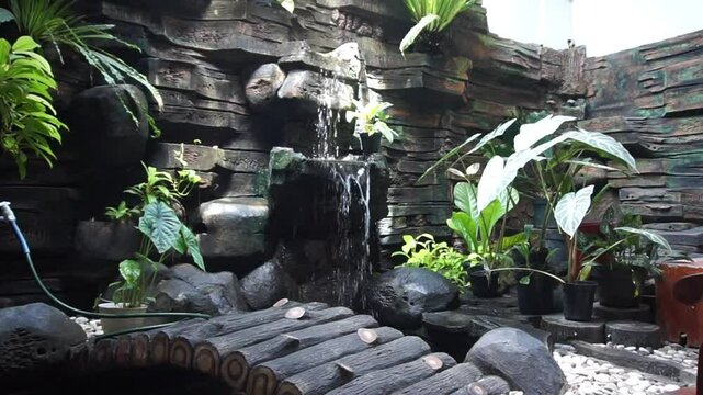 artificial mini waterfall and artificial rock wall and flowing water in artificial fish pond, and some beautiful ornamental plants