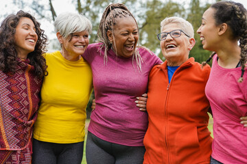 Multi generational women having fun hugging each other at city park - Multiracial group of people...