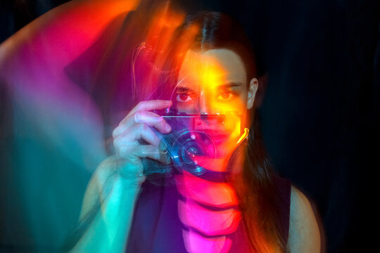 Vibrant long exposure portrait of woman with camera