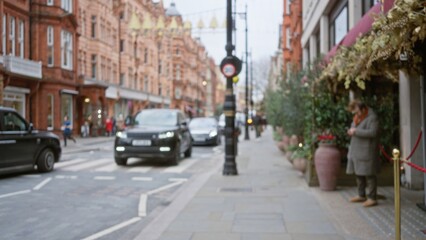 Blurred man on london street in winter surrounded by cars and buildings, capturing urban life through a bokeh perspective in the united kingdom.