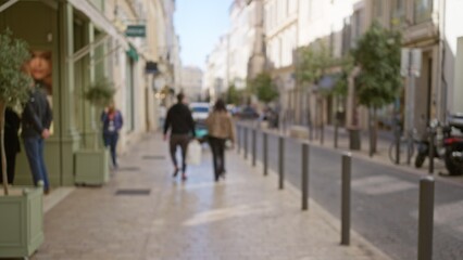 Blurred image of a street in marseilles featuring a man and woman walking outdoors with a bokeh effect in the background, capturing a vibrant european city atmosphere.