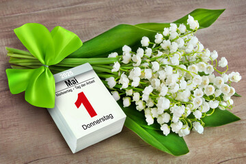Blumenstrauß mit Maiglöckchen und Deutscher Kalender 1. Mai 2025 auf Holz