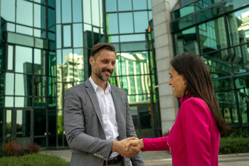 Business people, handshake and meeting in city for partnership, greeting or introduction and welcome outdoors. Happy woman with smile shaking hands for b2b, collaboration or agreement in deal outside