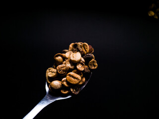 spoon filled with coffee beans
