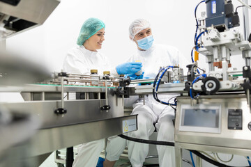 A careful examination of the product line by two professionals in a clean lab environment, highlighting teamwork and precision.