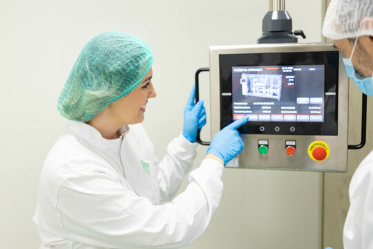 Operators analyze data from a digital interface in a lab, highlighting the importance of visual monitoring in machinery operations.