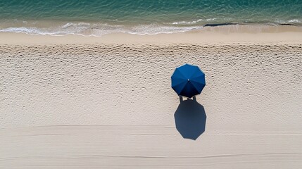 Serene Beach View Showcasing a Blue Umbrella on Golden Sand With Gentle Waves Lapping in the Background