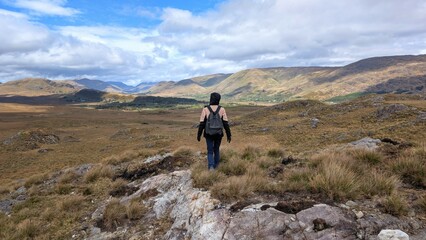 Obraz premium Young woman hiker backpacker hiking at Lackavrea mountain at Maum, Connemara national park, Galway, Ireland, nature adventure background