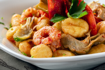 Gnocchi di patate con gamberi e carciofi, pasta italiana 