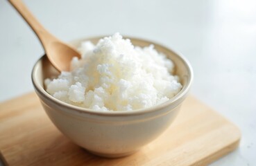 Tapioca starch in bowl on wooden board. White tapioca flour granules, spoon. Gluten free food, healthy eating concept. Ingredient cooking, baking, culinary, diet, breakfast, nutrition.