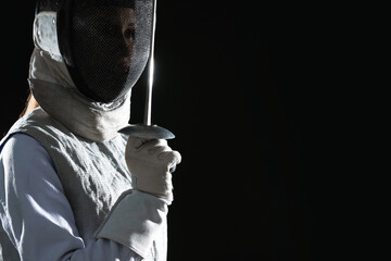 Fencer with epee on black background, space for text