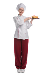 Happy confectioner in uniform holding delicious profiteroles with strawberries on white background