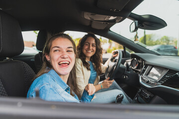 Young woman with cerebral palsy and assistant sharing joyful moment in car - Both smile warmly while seated in vehicle during outing for medical care - Concept of cerebral palsy

