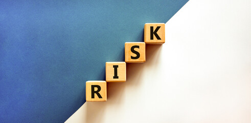 Risk symbol. Concept word Risk on beautiful wooden blocks. Beautiful white and blue background....