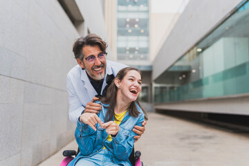 Doctor hugging cheerful young woman with cerebral palsy in wheelchair - Warm encounter outdoors...