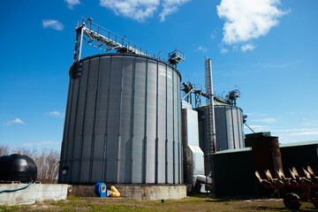 Modern elevator silo with clean sky background, symbol of grain storage and farming infrastructure.
