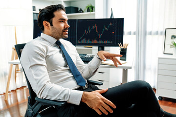 Smart trader businessman analyzing in two dynamic stock exchange investment screen on pc with investing highest profitable financial technology in searching market at modern home office. Surmise.