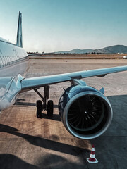 Fototapeta premium Close-up of the engine, wing and part of the fuselage of a classic passenger jet parked near a runway
