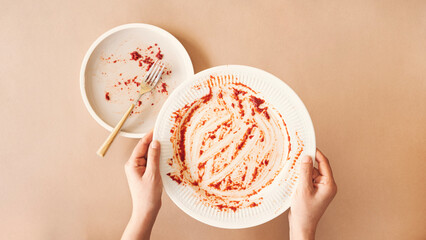 Hunger concept. Woman holding empty plate waiting for food. Top view
