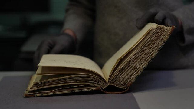 An archivist in gloves gently flips through an ancient archival book. Historical document handled with care. Ideal for themes of history, science, preservation, and cultural heritage