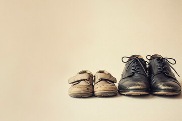 A pair of old children's and men's shoes on a light background. Space for text.