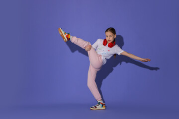 Girl with headphones dancing on purple background