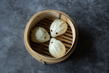 Adorably shaped Chinese steamed buns resembling hedgehogs, served in a traditional bamboo steamer...