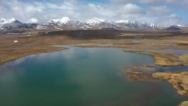 A stunning 4K drone view of Arabel Valley in Kyrgyzstan, highlighting the majestic Tien Shan mountains and dramatic cloudscapes over vast, open landscapes