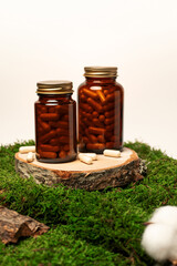 Herbal supplement capsules in amber jars on natural background. For natural, organic, and eco-friendly lifestyle, suitable for themes of wellness, alternative medicine,  and plant-based health product