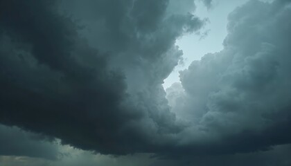 Obraz premium Dramatic photo of a black stormy sky covered with dark rain clouds. Moody atmosphere, heavy storm, nature landscape background. Overcast weather concept. Thunderstorm approaching.