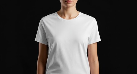 Woman wearing a plain white t-shirt against a dark background studio shot.