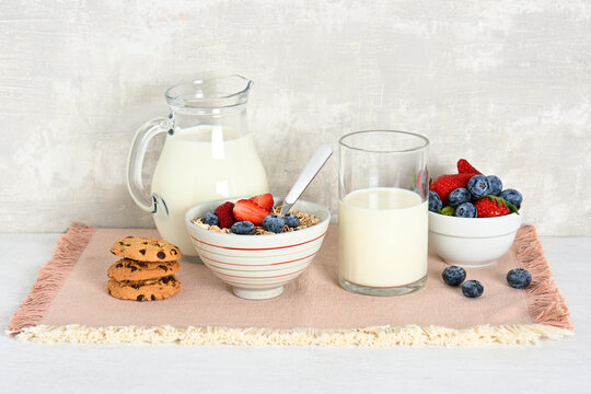 Arrangement of bowl with oat flakes, berries, cookies and milk