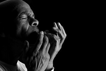 praying to god with hands together Caribbean man praying with black background with people stock photo stock image