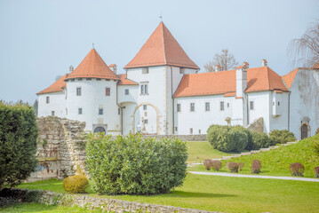 Naklejka premium Old Town Varaždin, Croatia: White castle with orange roofs and green lawn