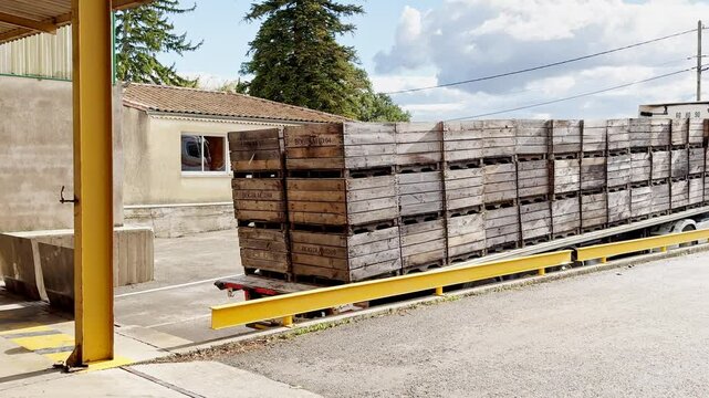 Valence, France - 6 July 2024: Truck loaded with wooden crates of apples destined for juice production. Efficient transportation of fresh fruit for processing in large-scale fruit juice production.