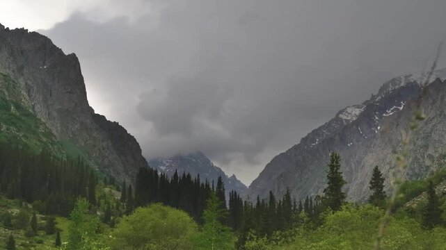 Timelapse of a mountain valley in Ala Archa National Park, Kyrgyzstan, with varied terrain and dramatic cloud cover showcasing the dynamic landscape.