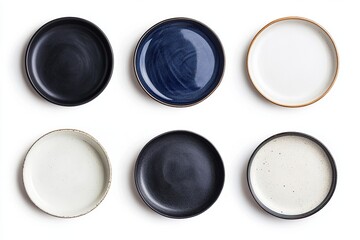 Overhead shot of six round ceramic plates in varying colors arranged on a white surface evenly spaced