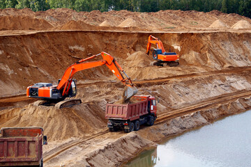 Loading sand into trucks at the sand quarry. Mining equipment and trucks
