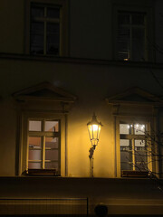 Windows Glowing with Light from Within, Framed by a Charming Vintage Street Lamp at Night